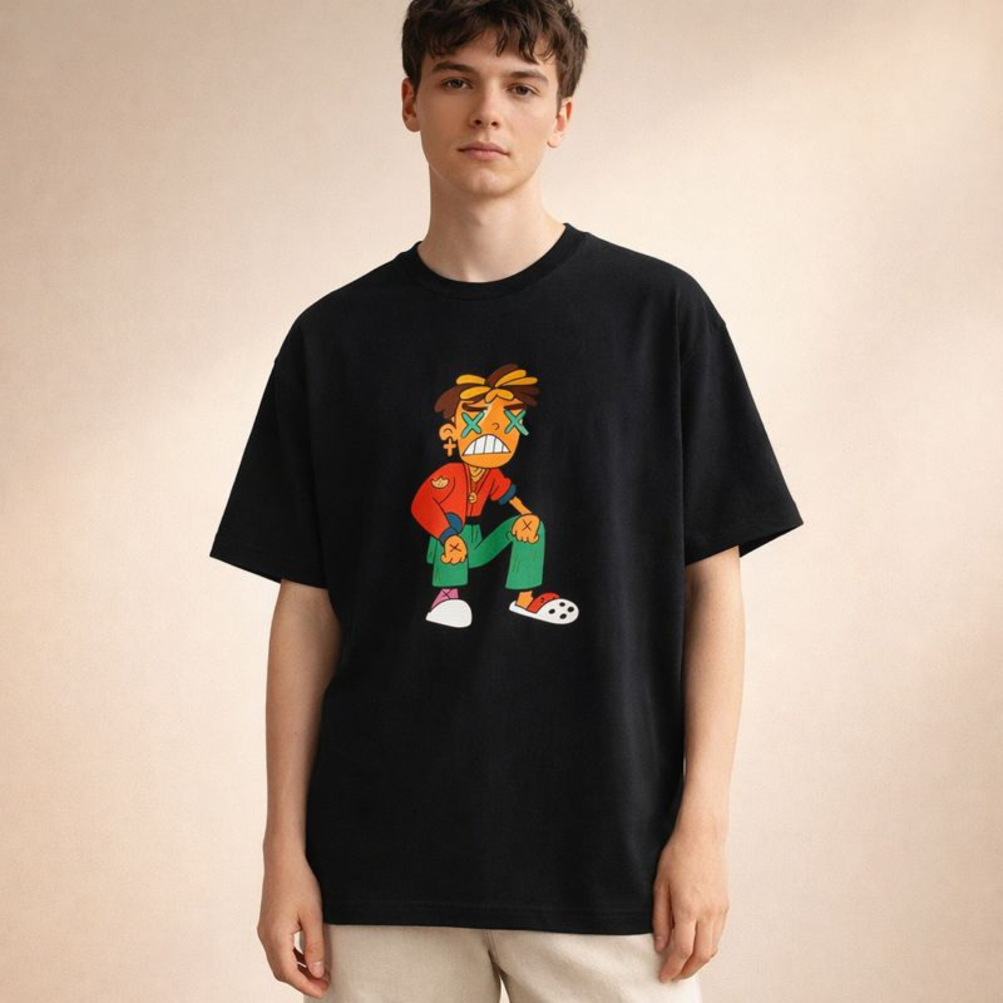 Black oversized streetwear tee with vivid cartoon figure print, modeled front-facing in softly lit cream studio backdrop